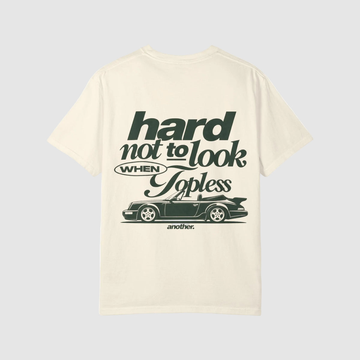 An off-white short-sleeve t-shirt with a dark green graphic print on the front. The graphic features stylized text reading 'hard not to look WHEN Topless' above a silhouette of a convertible sports car, with 'another.